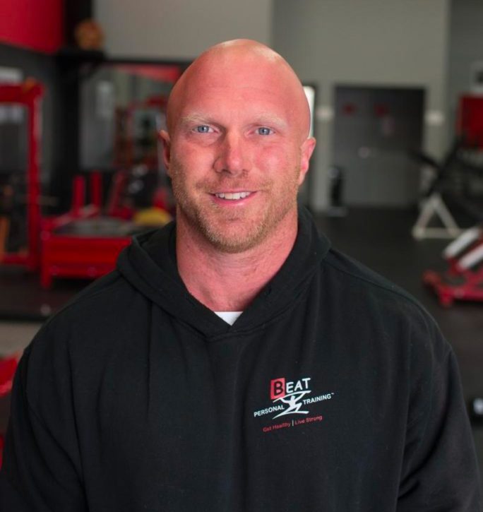 Man smiling at the gym in fitness attire.