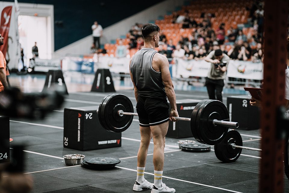 Man performing a deadlift at a competitive weightlifting event.